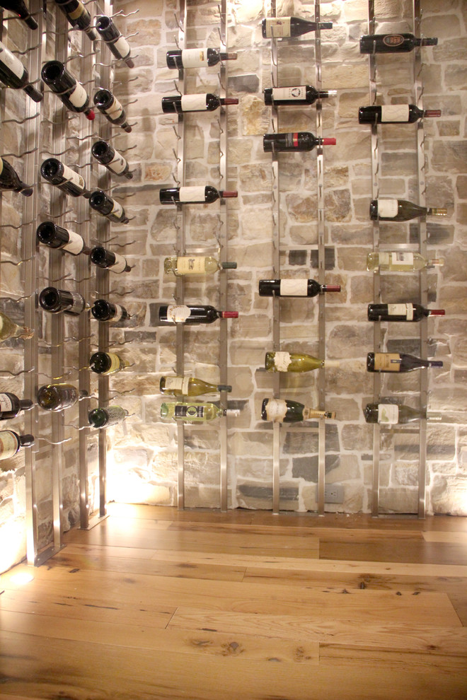 This is an example of a small beach style wine cellar in Orange County with medium hardwood floors and display racks.