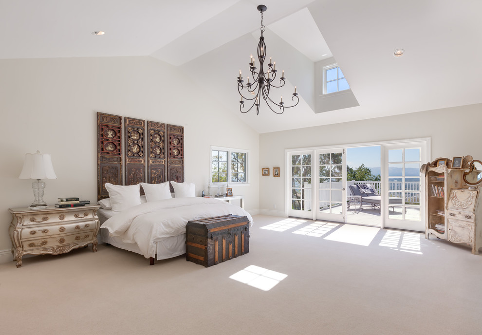 Photo of an expansive beach style master bedroom in Other with white walls, carpet and beige floor.