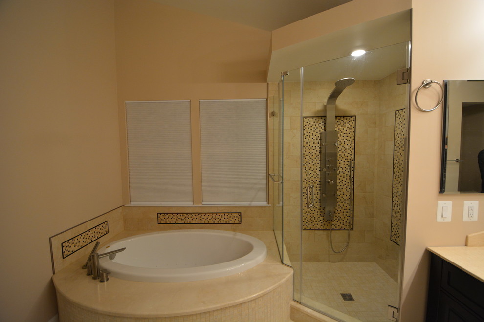 Inspiration for a large transitional master beige tile and stone tile marble floor and beige floor drop-in bathtub remodel in Baltimore with dark wood cabinets, a two-piece toilet, beige walls, an undermount sink, beaded inset cabinets, solid surface countertops, a hinged shower door and beige countertops