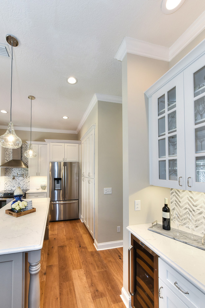 Example of a large transitional l-shaped medium tone wood floor eat-in kitchen design in Jacksonville with a farmhouse sink, shaker cabinets, quartz countertops and an island