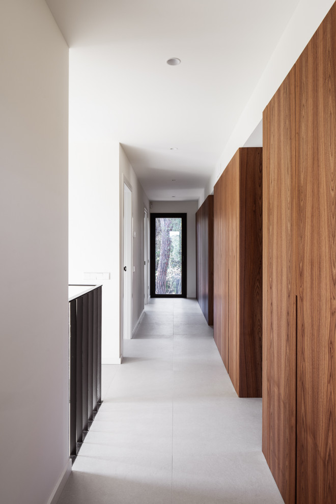 Foto di un ingresso o corridoio mediterraneo di medie dimensioni con pareti bianche, pavimento con piastrelle in ceramica, pavimento beige e pareti in legno