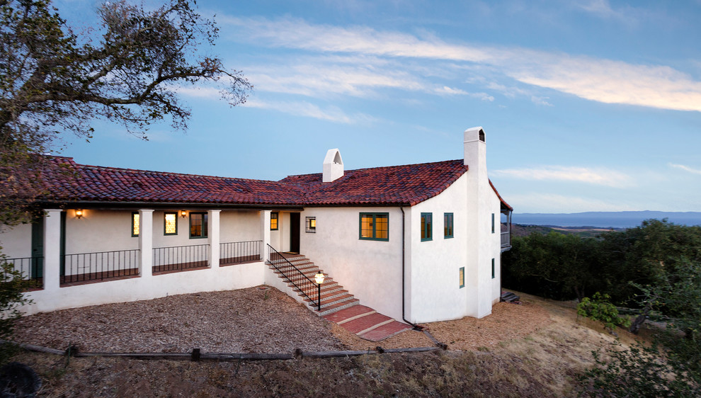 This is an example of a mid-sized mediterranean split-level stucco white exterior in Santa Barbara.