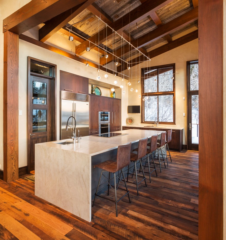 Photo of a contemporary l-shaped kitchen in Denver with an undermount sink, flat-panel cabinets, dark wood cabinets, stainless steel appliances, dark hardwood floors, with island and brown floor.