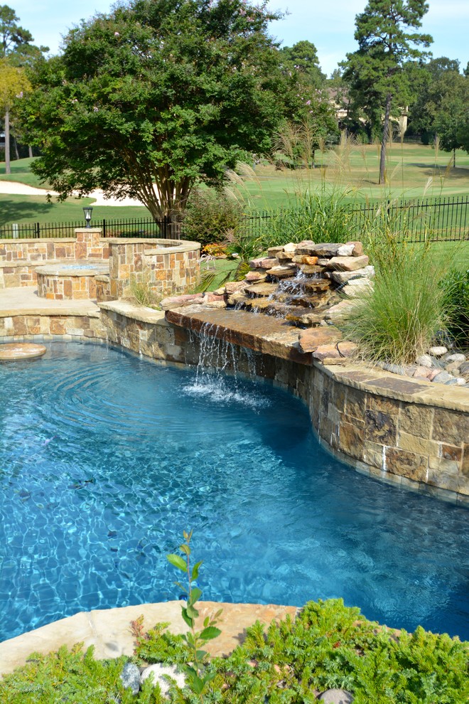 This is an example of a backyard custom-shaped pool in Little Rock with a hot tub.