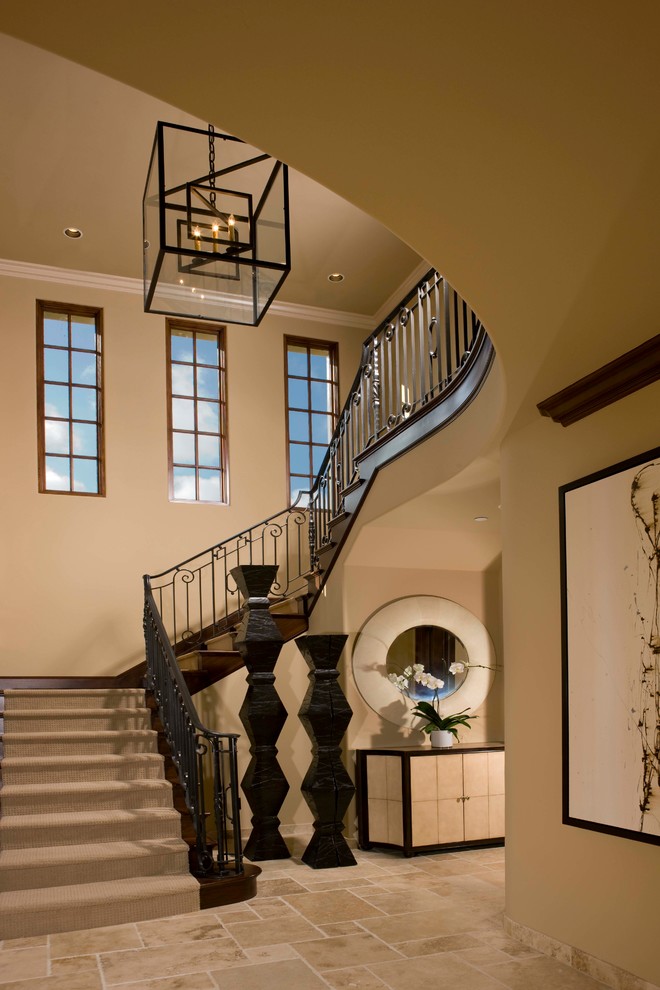 Photo of a large mediterranean carpeted u-shaped staircase in San Diego with carpet risers and metal railing.