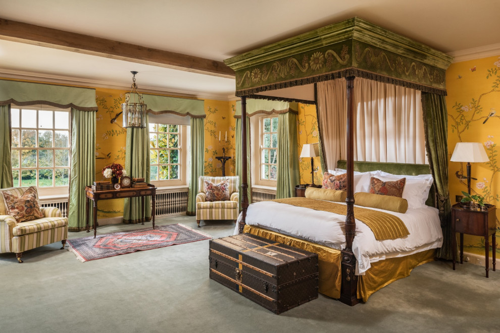 Inspiration for a large traditional master bedroom in Sussex with yellow walls, carpet and green floor.
