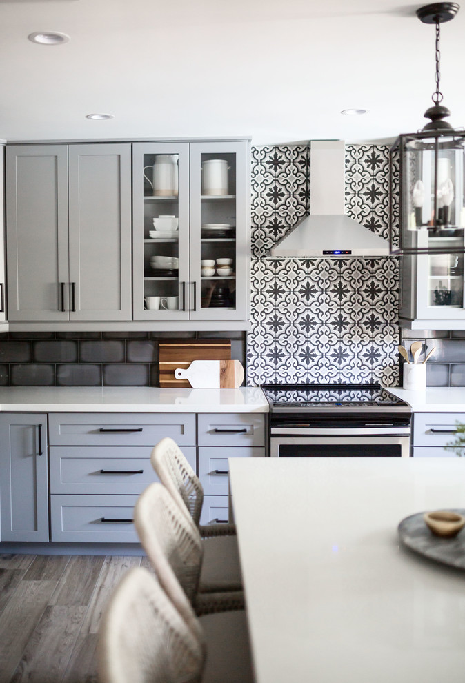 Eat-in kitchen - mid-sized transitional u-shaped light wood floor and gray floor eat-in kitchen idea in Phoenix with an undermount sink, recessed-panel cabinets, gray cabinets, quartz countertops, multicolored backsplash, ceramic backsplash, stainless steel appliances, an island and white countertops