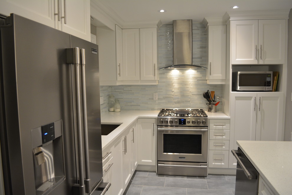 Example of a mid-sized transitional l-shaped porcelain tile eat-in kitchen design in Toronto with an undermount sink, shaker cabinets, white cabinets, quartzite countertops, stainless steel appliances, an island, gray backsplash and matchstick tile backsplash