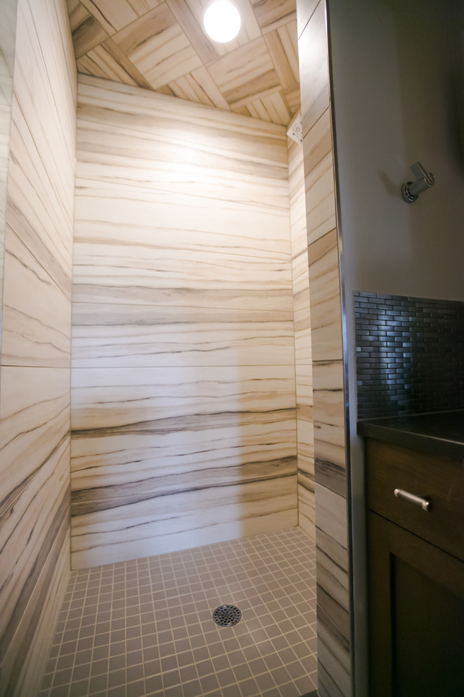 Inspiration for a mid-sized transitional kids bathroom in Indianapolis with ceramic floors, multi-coloured floor, a hinged shower door, recessed-panel cabinets, medium wood cabinets, an alcove shower, beige tile, ceramic tile, brown walls, engineered quartz benchtops and black benchtops.