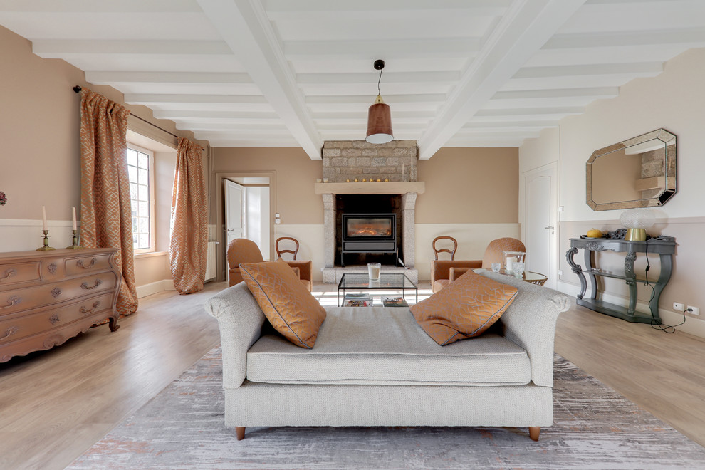 Expansive transitional open concept living room in Le Havre with linoleum floors, a wood stove, a library, beige walls and a stone fireplace surround.