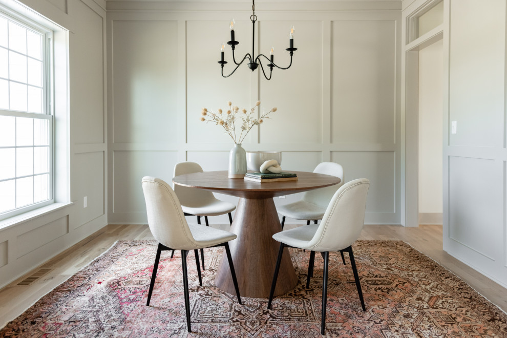 Inspiration for a transitional dining room in Milwaukee with white walls, light hardwood floors, beige floor and panelled walls.