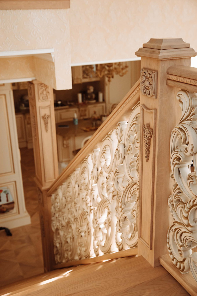 Пример оригинального дизайна: большая п-образная деревянная лестница в классическом стиле с деревянными ступенями, деревянными перилами, обоями на стенах и кладовкой или шкафом под ней