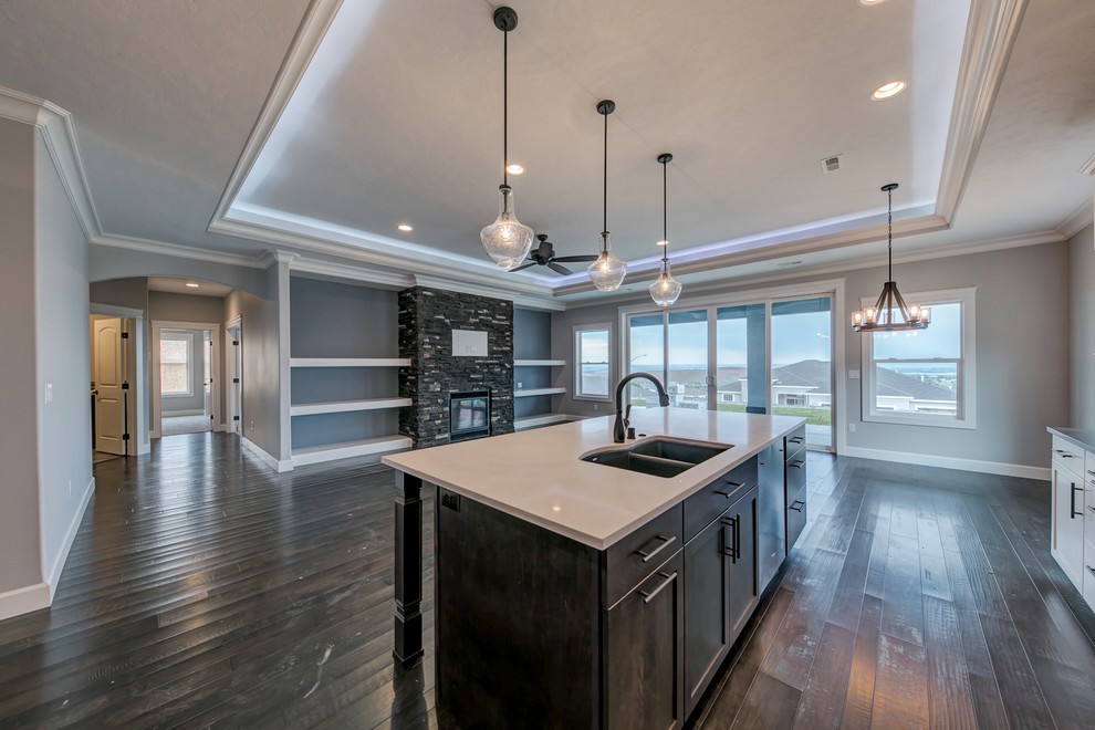 Mid-sized transitional single-wall medium tone wood floor open concept kitchen photo in Seattle with an undermount sink, shaker cabinets, white cabinets, quartz countertops, gray backsplash, glass tile backsplash, stainless steel appliances and an island