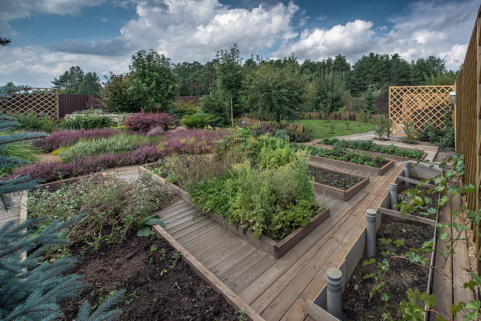This is an example of a traditional shaded garden for summer in Moscow with a vegetable garden and decking.