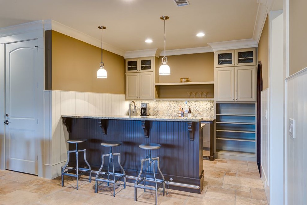Inspiration for a mid-sized arts and crafts u-shaped seated home bar in Atlanta with an undermount sink, raised-panel cabinets, granite benchtops, multi-coloured splashback, glass tile splashback, ceramic floors and beige cabinets.