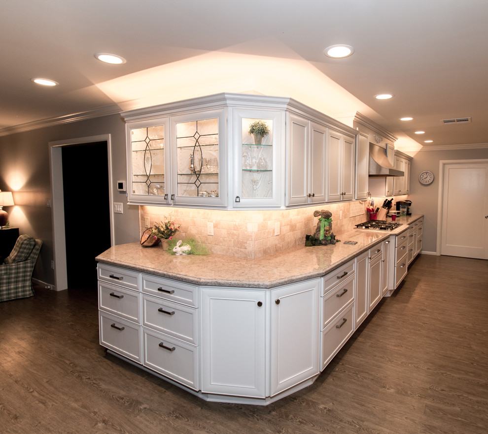 Example of a huge transitional open concept kitchen design with a farmhouse sink, recessed-panel cabinets, white cabinets, quartz countertops, beige backsplash, stone tile backsplash, stainless steel appliances and an island
