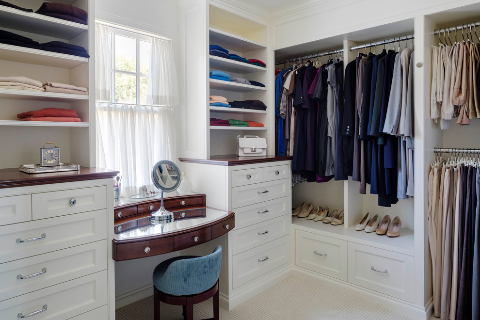 Photo of a mid-sized traditional gender-neutral walk-in wardrobe in Boston with beaded inset cabinets, white cabinets, carpet and beige floor.