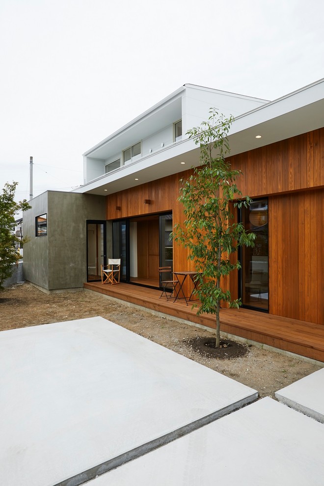 Inspiration för en mellanstor funkis terrass längs med huset, med takförlängning
