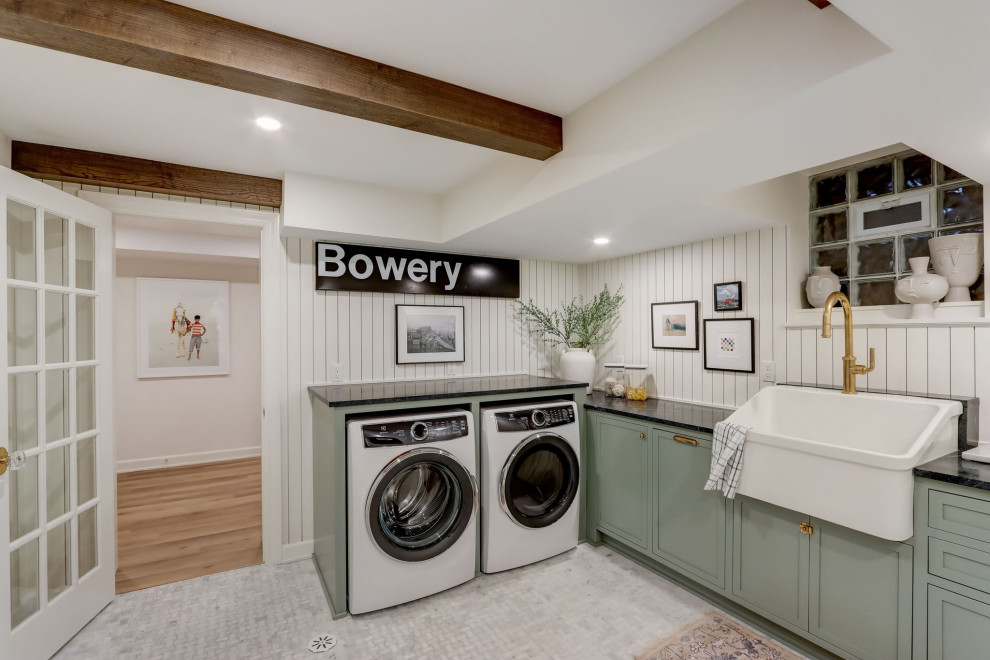Mid-sized transitional u-shaped marble floor, white floor, exposed beam and wall paneling dedicated laundry room photo in Milwaukee with a farmhouse sink, recessed-panel cabinets, marble countertops, white backsplash, shiplap backsplash, white walls, a side-by-side washer/dryer and black countertops