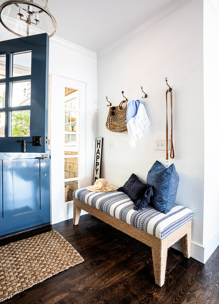This is an example of a mid-sized beach style front door in Sacramento with white walls, dark hardwood floors, a blue front door, a dutch front door and brown floor.