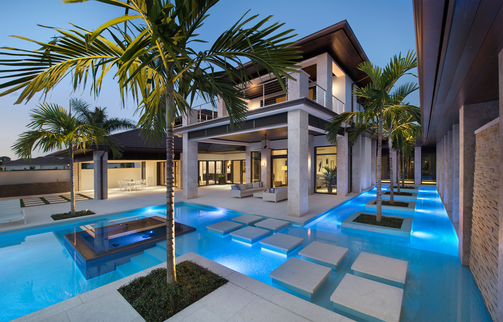 Pool - tropical backyard stamped concrete and custom-shaped pool idea in Miami