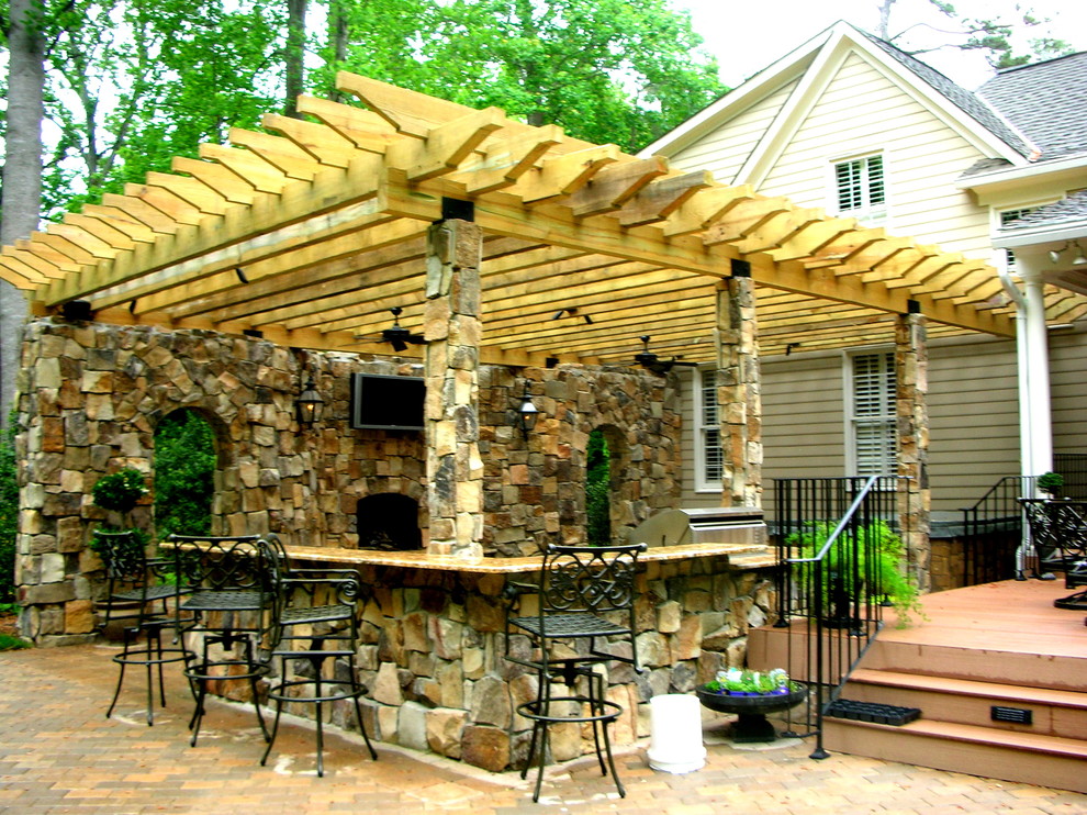 Patio kitchen - mid-sized rustic backyard concrete paver patio kitchen idea with a pergola