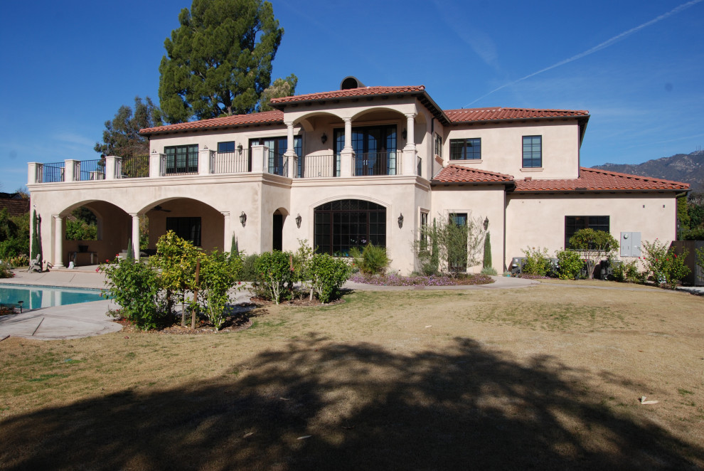 Großes, Zweistöckiges Mediterranes Einfamilienhaus mit Putzfassade, beiger Fassadenfarbe, Walmdach, Ziegeldach und rotem Dach in Los Angeles