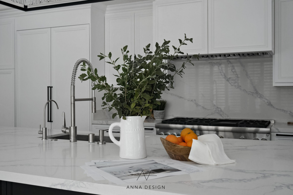Large transitional l-shaped light wood floor and gray floor open concept kitchen photo in Los Angeles with a drop-in sink, louvered cabinets, white cabinets, quartzite countertops, white backsplash, quartz backsplash, stainless steel appliances, an island and white countertops