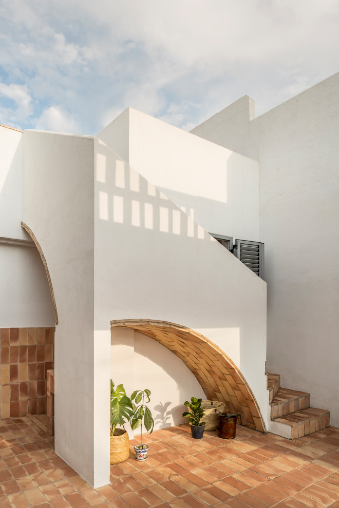 Aménagement d'une terrasse méditerranéenne de taille moyenne avec une cour, des pavés en brique et un auvent.