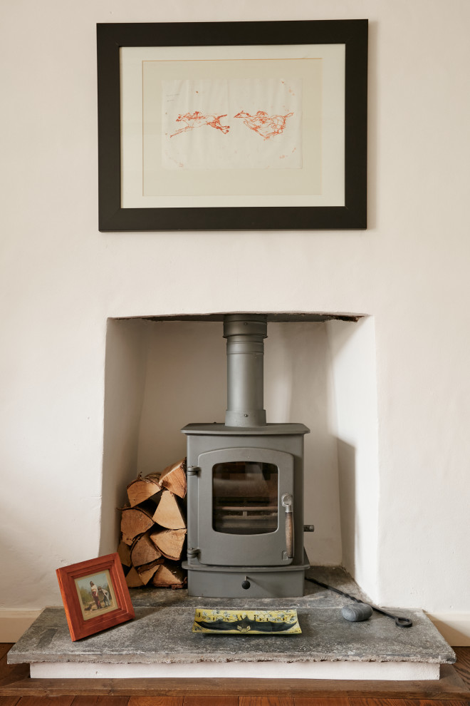 This is an example of a traditional living room in Cornwall with a wood stove and a plaster fireplace surround.