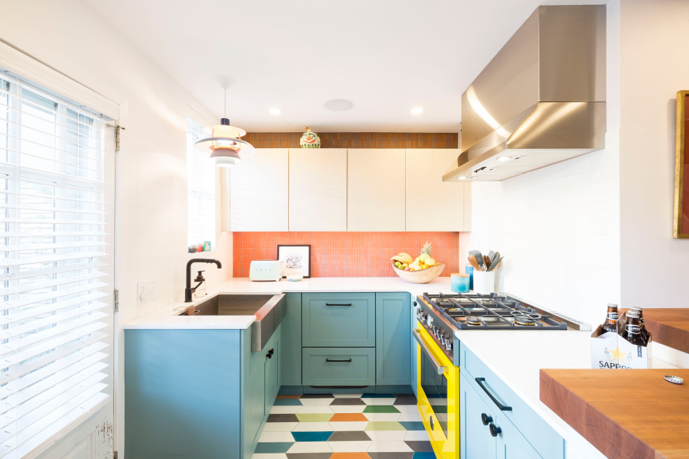 Exempel på ett eklektiskt vit vitt u-kök, med en rustik diskho, bänkskiva i kvarts, stänkskydd i mosaik, färgglada vitvaror, cementgolv, flerfärgat golv, skåp i shakerstil, blå skåp och orange stänkskydd