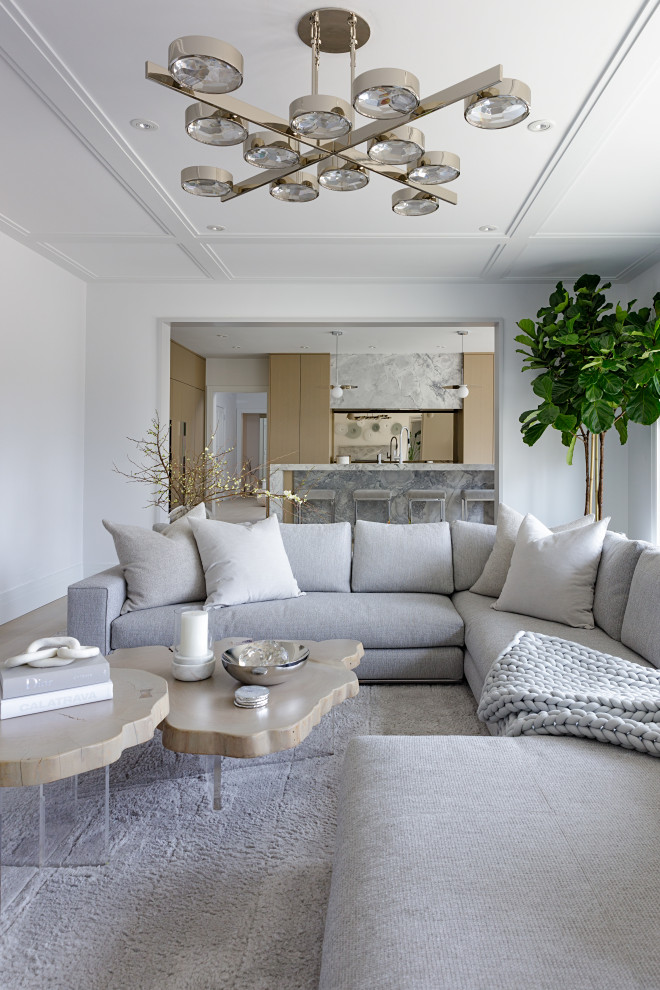 Exempel på ett mycket stort modernt grå grått kök, med en undermonterad diskho, släta luckor, beige skåp, marmorbänkskiva, spegel som stänkskydd, integrerade vitvaror, ljust trägolv, en köksö och beiget golv