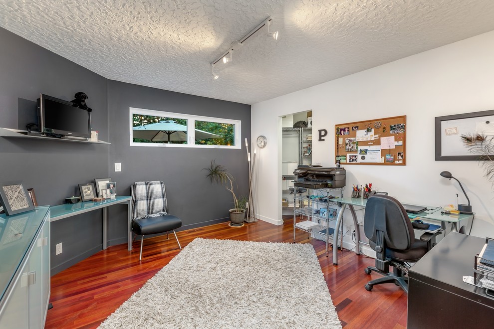 This is an example of a small modern home office in Portland with grey walls, dark hardwood floors and multi-coloured floor.