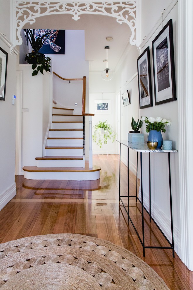 Photo of a large scandinavian entryway in Melbourne with white walls, medium hardwood floors, a single front door and a black front door.
