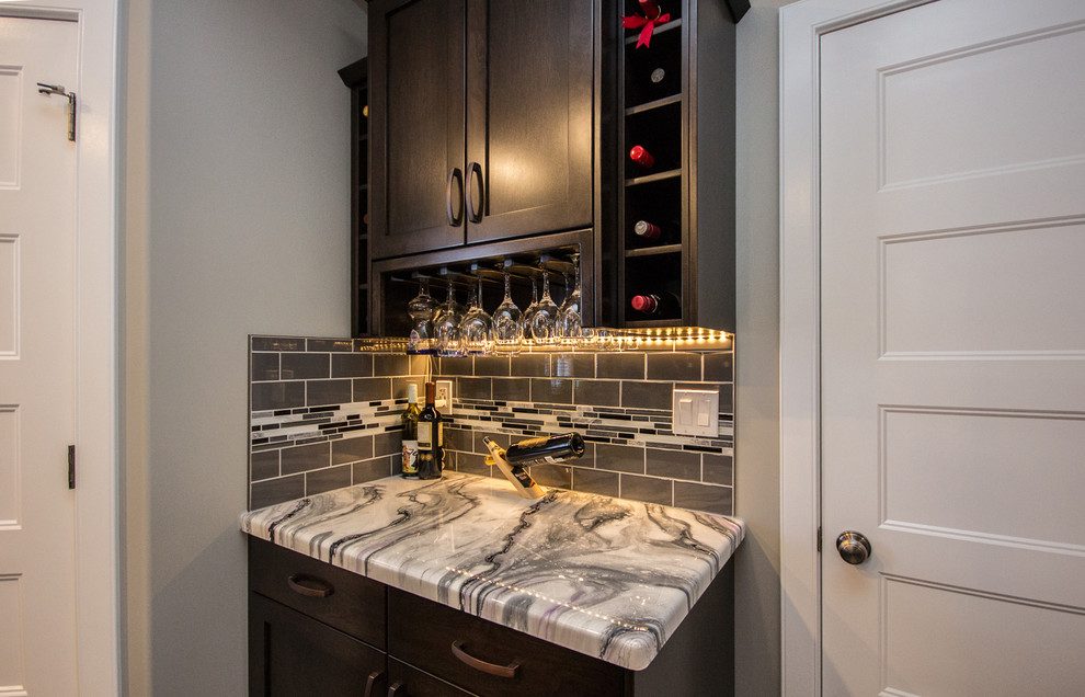 Photo of a small contemporary single-wall home bar in Calgary with shaker cabinets, dark wood cabinets, marble benchtops, grey splashback, subway tile splashback and porcelain floors.