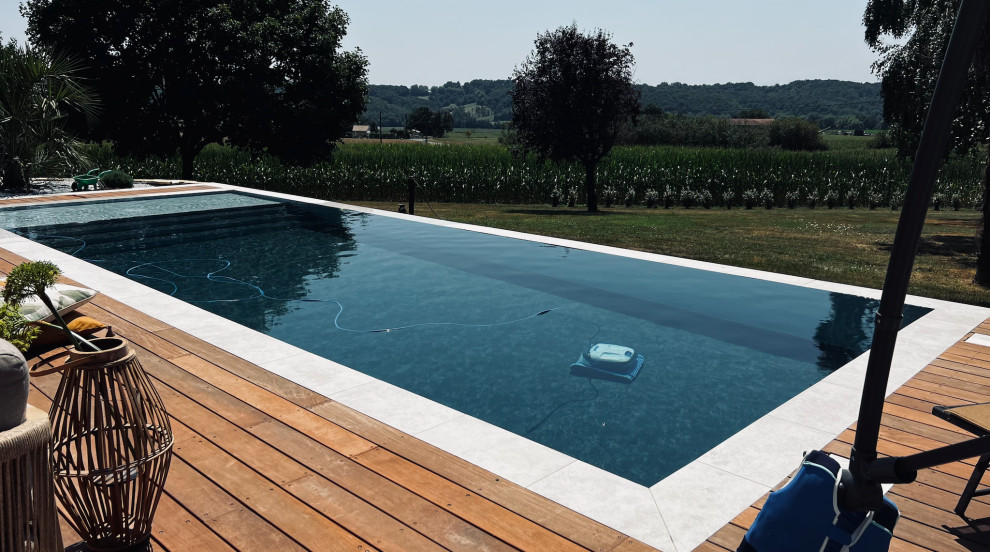 This is an example of a large contemporary front rectangular lengths swimming pool in Toulouse with with pool landscaping.