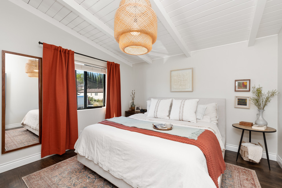 Cette image montre une petite chambre d'amis vintage avec un mur blanc, un sol en bois brun, un sol marron et un plafond en lambris de bois.