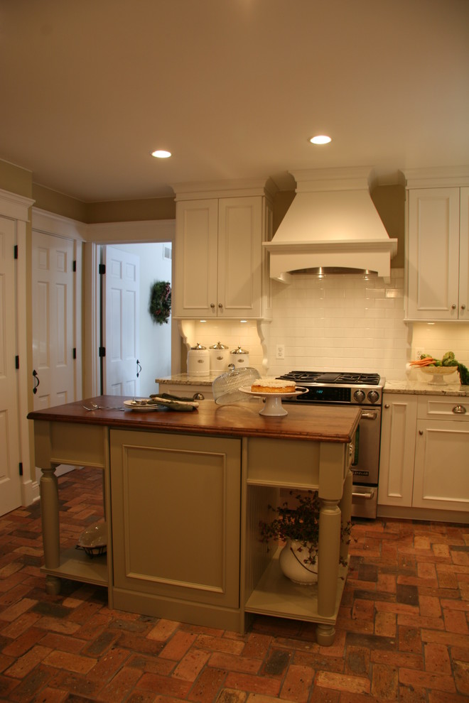 Inspiration for a mid-sized craftsman u-shaped brick floor eat-in kitchen remodel in Chicago with a farmhouse sink, flat-panel cabinets, white cabinets, granite countertops, white backsplash, ceramic backsplash, paneled appliances, yellow walls and an island