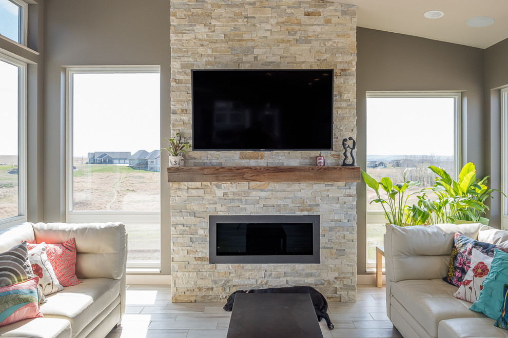 This is an example of a mid-sized modern open concept living room in Other with a wall-mounted tv, grey walls, ceramic floors, a standard fireplace and a stone fireplace surround.