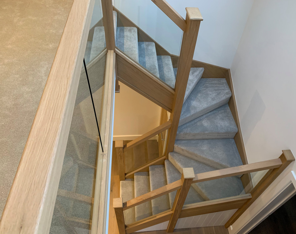 Photo of a mid-sized contemporary carpeted u-shaped staircase in Cornwall with carpet risers and mixed railing.