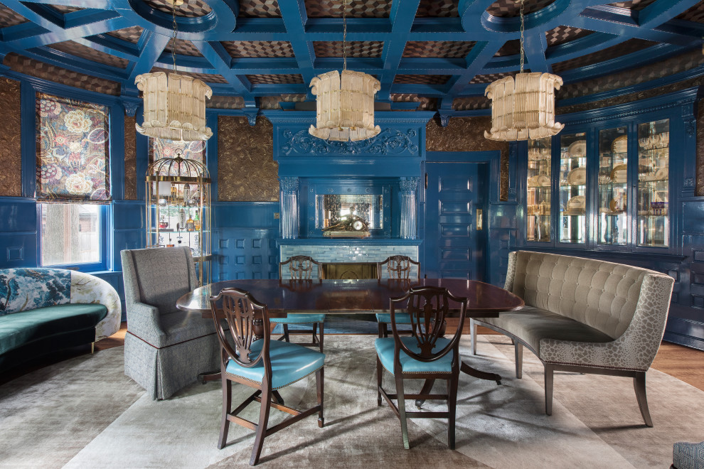 Cette photo montre une grande salle à manger éclectique fermée avec un mur bleu, un sol en bois brun, une cheminée standard, un manteau de cheminée en carrelage, un sol marron, un plafond à caissons et du papier peint.