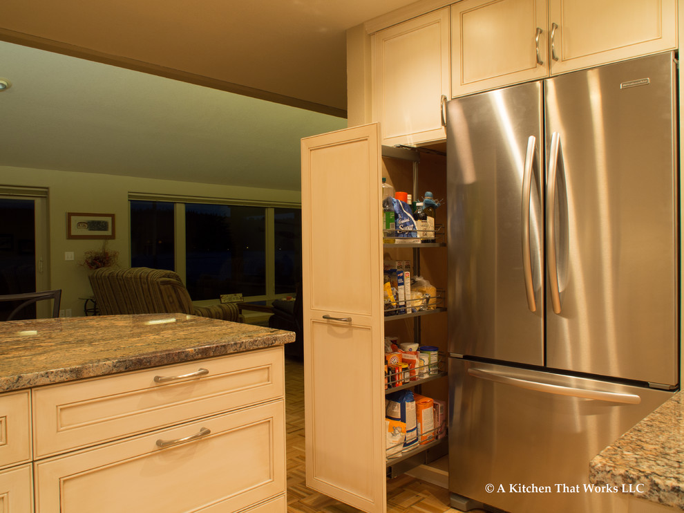 Large transitional u-shaped medium tone wood floor and brown floor eat-in kitchen photo in Seattle with an undermount sink, recessed-panel cabinets, white cabinets, granite countertops, stone slab backsplash, stainless steel appliances, an island, brown backsplash and brown countertops