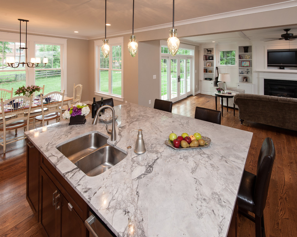 Photo of a large traditional l-shaped open plan kitchen in DC Metro with a drop-in sink, beaded inset cabinets, white cabinets, marble benchtops, dark hardwood floors and with island.