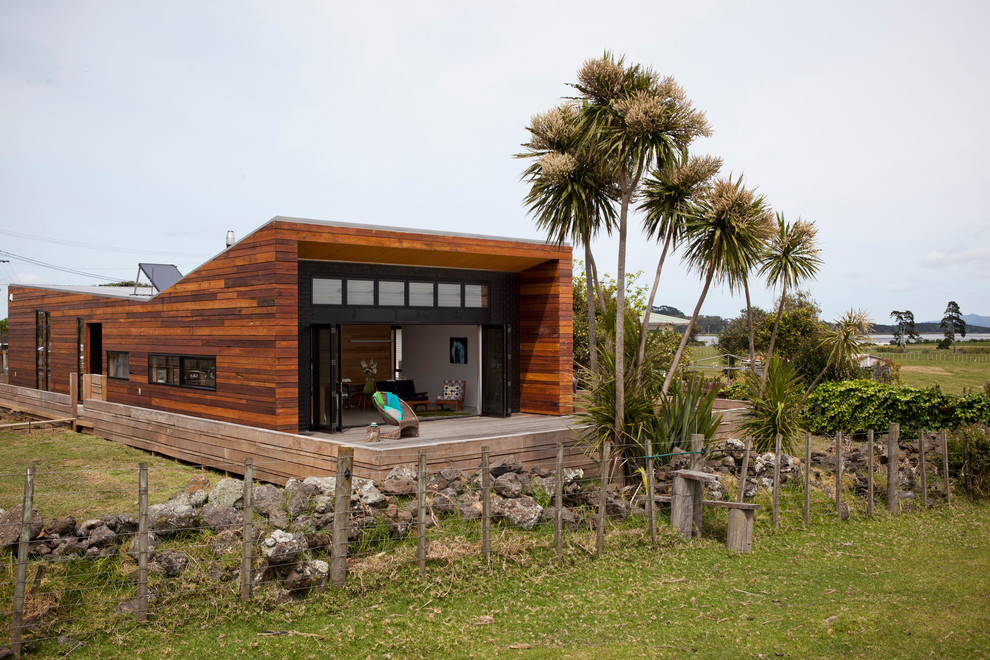 Photo of a small contemporary one-storey brown exterior in Auckland with wood siding and a flat roof.
