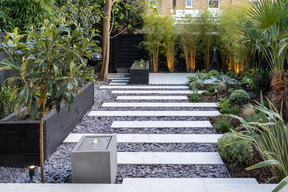 Photo of a medium sized contemporary back xeriscape full sun garden for summer in London with natural stone paving.