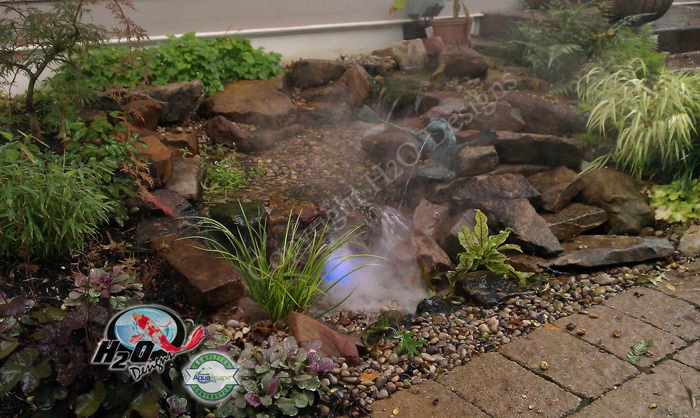 Design ideas for a large eclectic backyard partial sun garden in Louisville with a water feature and brick pavers.