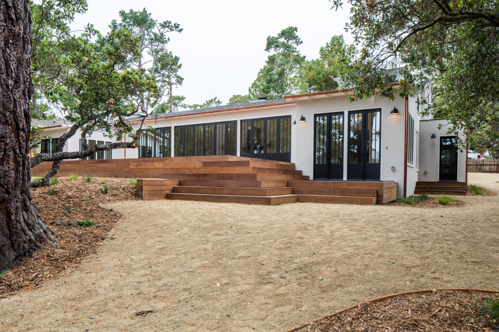 Large transitional beige split-level stucco house exterior idea with a hip roof and a shingle roof