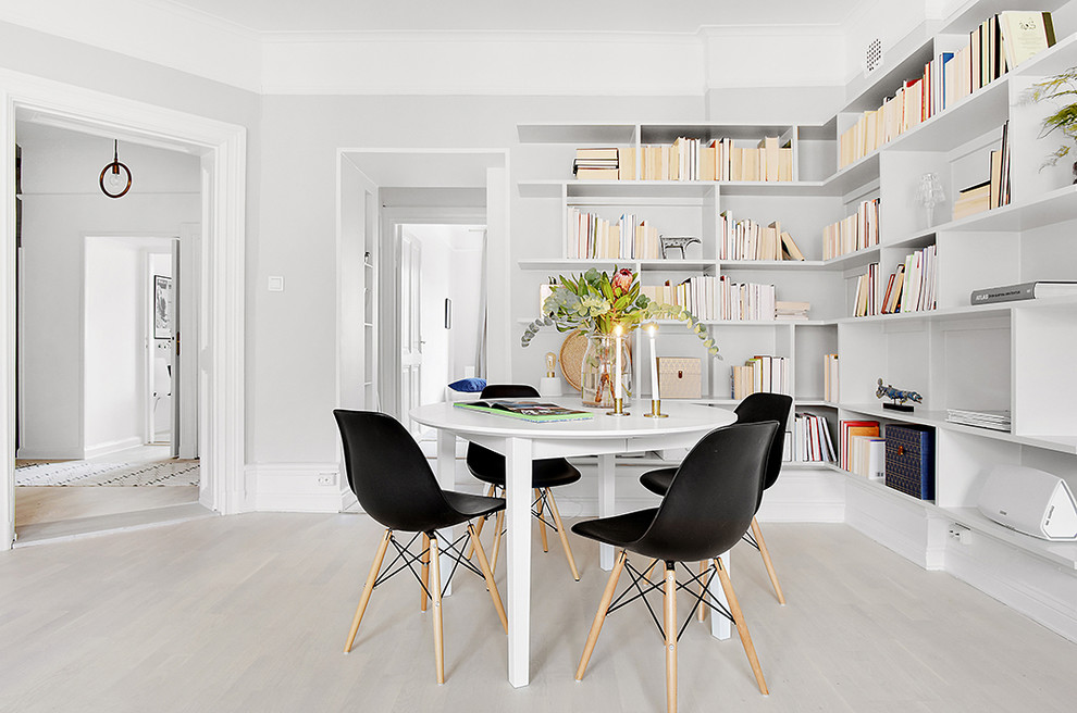 This is an example of a mid-sized contemporary open plan dining in Stockholm with white walls and light hardwood floors.