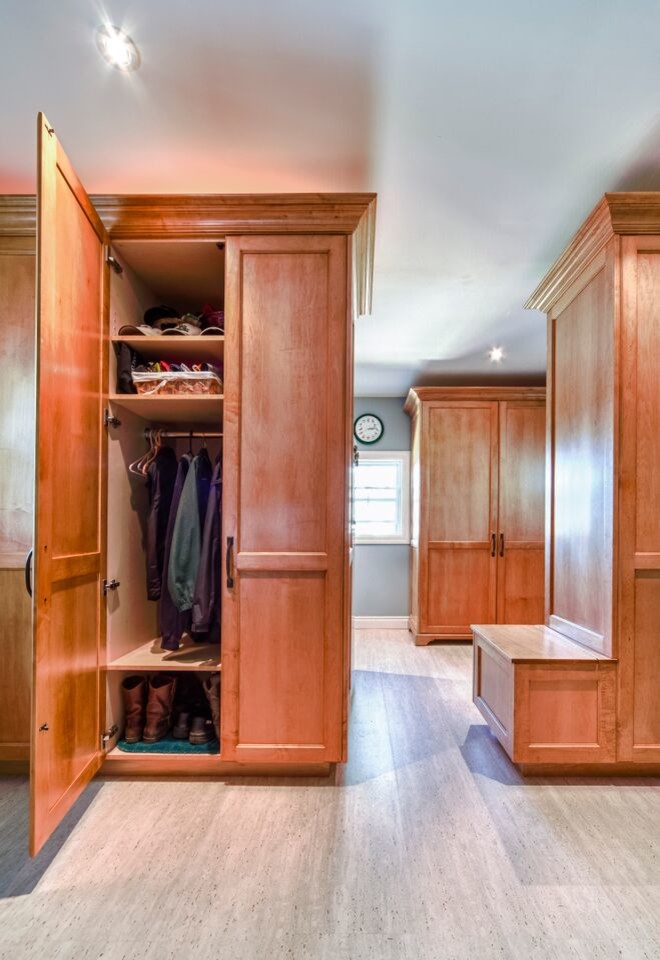 This is an example of a large transitional gender-neutral walk-in wardrobe in Toronto with shaker cabinets, medium wood cabinets and linoleum floors.
