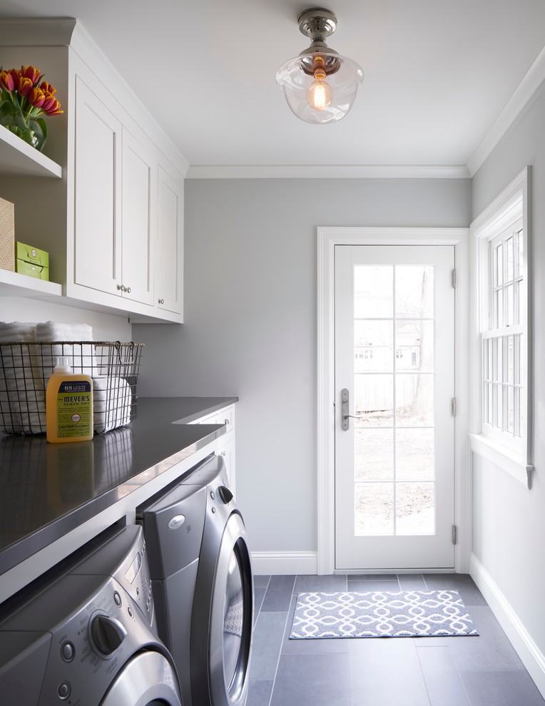 Design ideas for a small transitional single-wall dedicated laundry room in Minneapolis with shaker cabinets, white cabinets, solid surface benchtops, grey walls, porcelain floors, a side-by-side washer and dryer and grey benchtop.